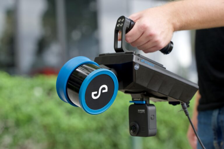 Hovermap ST-Xをハンドヘルドグリップに取り付けて計測している様子
