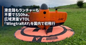 草地の離着陸マット上に立つWingtraRAYと、広域測量・国内初飛行を伝えるブログヒーロー画像