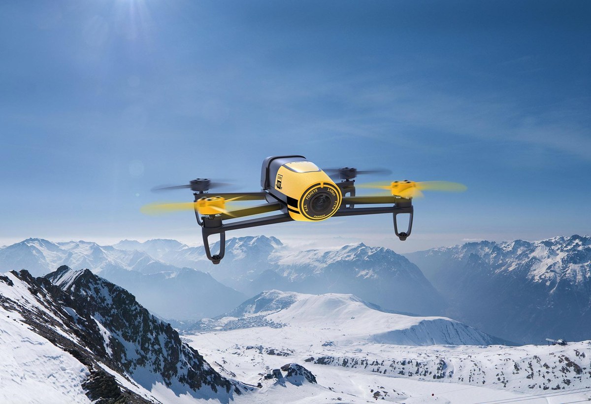 雪山を背景に飛ぶ黄色のParrot Bebop Drone
